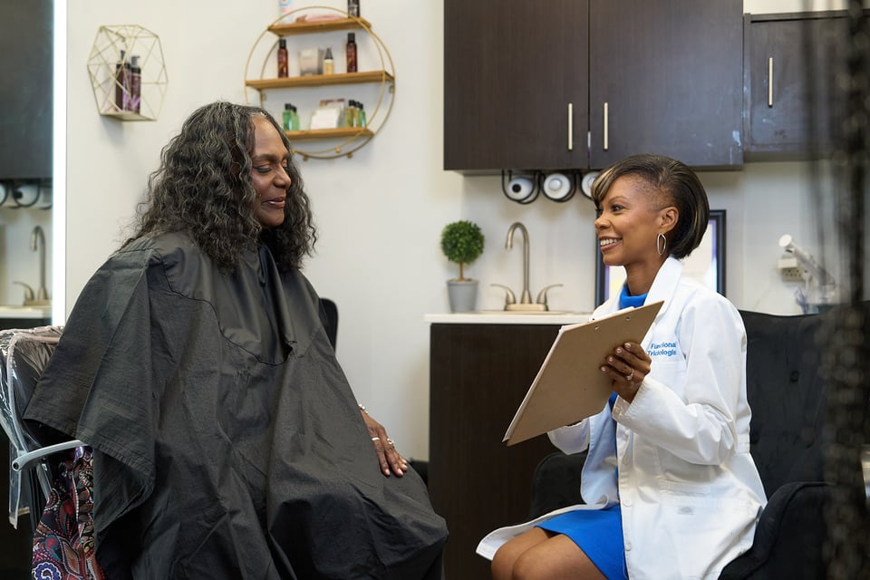 Shameika Bolden meeting with a client during a hair and scalp consultation